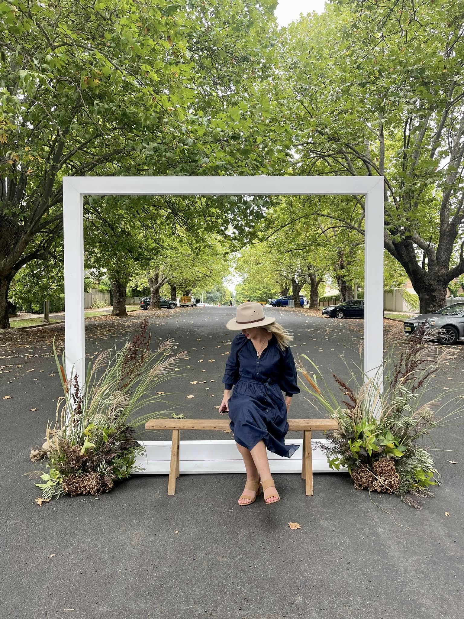 Jen seated beneath leafy street trees in Orange