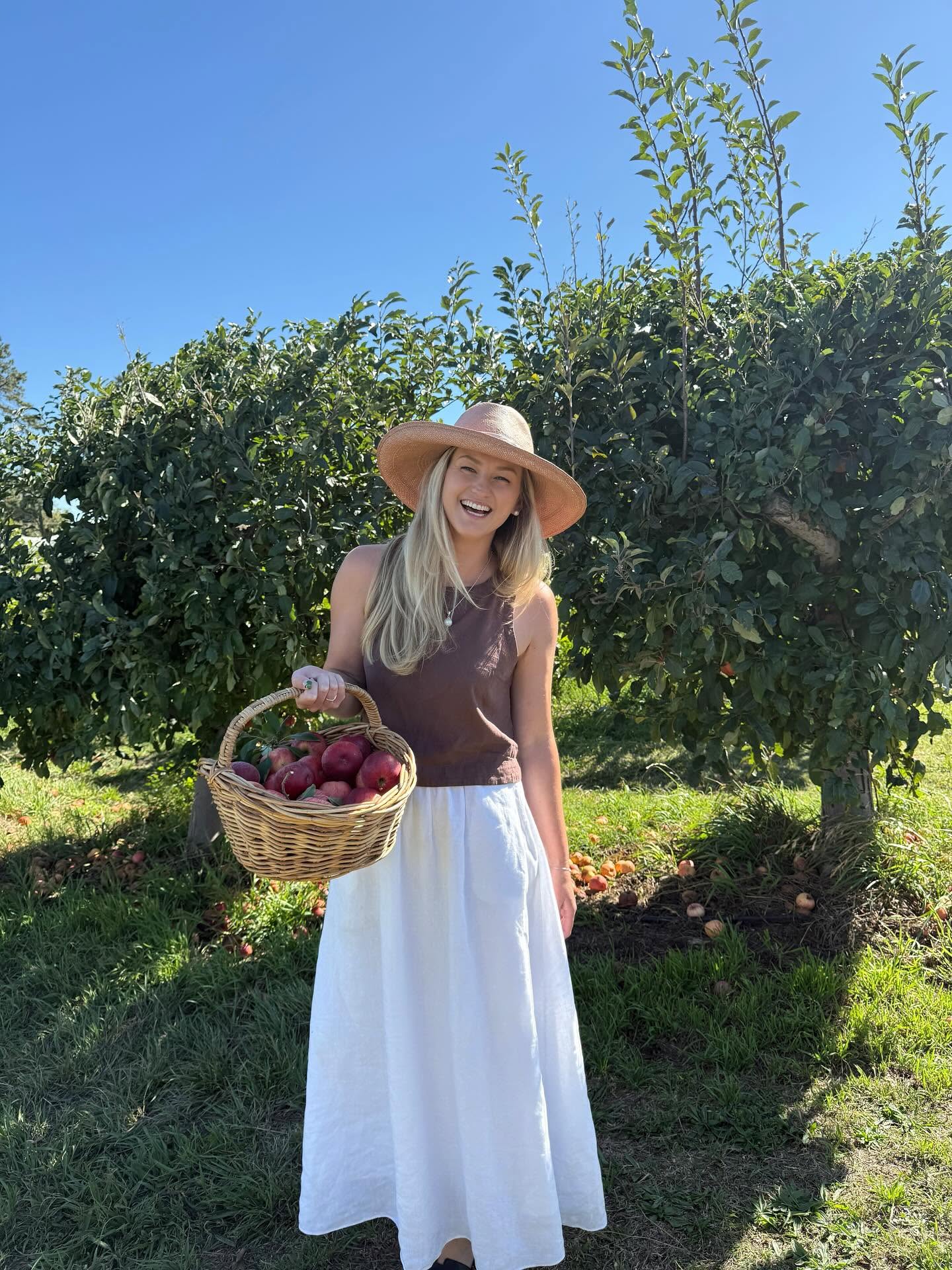 Jen picking apples in an orchard near Orange